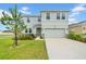 Charming two-story home with stone accents, a two-car garage and landscaped front yard at 32136 Conchshell Sail St, Wesley Chapel, FL 33545