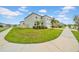 Well-kept two-story home with green lawn, landscaped beds, and sidewalks at 32136 Conchshell Sail St, Wesley Chapel, FL 33545