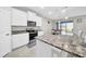 Modern kitchen with white cabinets, granite countertops, and stainless steel appliances at 32136 Conchshell Sail St, Wesley Chapel, FL 33545
