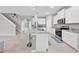 Open kitchen features white cabinets, granite counters, stainless appliances, and an island with bar stools at 32136 Conchshell Sail St, Wesley Chapel, FL 33545