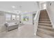 Spacious living room features tile floors, large windows, and a staircase leading to the upper level at 32136 Conchshell Sail St, Wesley Chapel, FL 33545