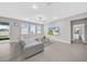 Bright living room boasts a comfortable sectional sofa, tiled flooring, and backyard views at 32136 Conchshell Sail St, Wesley Chapel, FL 33545