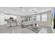Open floor plan with modern living area and bright kitchen featuring pendant lighting and bar seating at 32136 Conchshell Sail St, Wesley Chapel, FL 33545