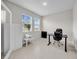 Comfortable home office with large windows, black desk, and sleek furnishings at 32136 Conchshell Sail St, Wesley Chapel, FL 33545