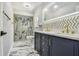 Beautiful bathroom with navy vanity, marble accents, and glass shower at 325 Gladstone Blvd, Englewood, FL 34223