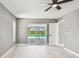 Bright bedroom with fan, view to pool with sliding doors, and white door at 325 Gladstone Blvd, Englewood, FL 34223