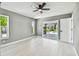 Bright bedroom with fan, view to pool with sliding doors and white door at 325 Gladstone Blvd, Englewood, FL 34223
