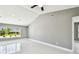 Bright bedroom with neutral paint, vaulted ceiling, large windows with backyard views, and white tile flooring at 325 Gladstone Blvd, Englewood, FL 34223