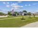 Quaint single-story home featuring a well-kept lawn, palm trees, and an American flag at 325 Gladstone Blvd, Englewood, FL 34223