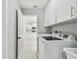 Bright laundry room with appliances and white storage cabinets at 325 Gladstone Blvd, Englewood, FL 34223
