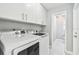 Laundry room featuring appliances and white overhead storage at 325 Gladstone Blvd, Englewood, FL 34223