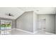 Bright living room with fan, vaulted ceiling, and glass sliding doors with pool view at 325 Gladstone Blvd, Englewood, FL 34223