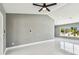 Bright living room featuring a ceiling fan, large window, and modern tile floors at 325 Gladstone Blvd, Englewood, FL 34223