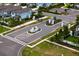 Aerial view of the residential neighborhood showcasing lush landscaping, a decorative roundabout, and well-maintained streets at 3559 Maple Bay Ln, Land O Lakes, FL 34638