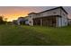 Rear exterior of homes with screened-in patios backing up to a large green lawn at 3559 Maple Bay Ln, Land O Lakes, FL 34638
