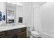 Bright bathroom featuring quartz countertop, wood cabinets, tiled shower and toilet at 3559 Maple Bay Ln, Land O Lakes, FL 34638