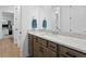 Bathroom featuring quartz countertop, wood cabinets, and two towel racks with a view into the walk-in shower at 3559 Maple Bay Ln, Land O Lakes, FL 34638