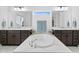 Bright bathroom with double sinks, soaking tub, and oversized mirrors with views through the window at 3559 Maple Bay Ln, Land O Lakes, FL 34638