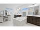 This bathroom includes double sink, a stand alone soaking tub and vanity area with mirror and stool at 3559 Maple Bay Ln, Land O Lakes, FL 34638