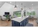 Stylish kitchen with island seating, pendant lighting, and views of the living area and backyard pond at 3559 Maple Bay Ln, Land O Lakes, FL 34638