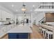 Open-concept kitchen with a large island, stainless appliances, and seamless flow into the living space with wood floors at 3559 Maple Bay Ln, Land O Lakes, FL 34638