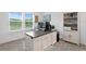 A well-lit home office space with a gray and white desk, large window, and built-in shelving unit at 3559 Maple Bay Ln, Land O Lakes, FL 34638