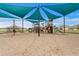 Community playground with shade structure and several play structures for children at 3559 Maple Bay Ln, Land O Lakes, FL 34638