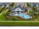 Aerial view of community pool and clubhouse surrounded by well-maintained landscaping and plenty of outdoor seating at 3559 Maple Bay Ln, Land O Lakes, FL 34638