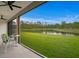 Screened-in porch with an outdoor view of the lawn, lake, and trees at 3559 Maple Bay Ln, Land O Lakes, FL 34638