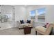 Bright sitting area features neutral colored furniture, carpet, and two windows with white trim and privacy shades at 3559 Maple Bay Ln, Land O Lakes, FL 34638