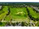 Aerial view of golf course featuring driving range and manicured greens at 3633 Morgans Bluff Ct, Land O Lakes, FL 34639