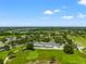 Expansive aerial view of community clubhouse and golf course under bright blue sky at 3633 Morgans Bluff Ct, Land O Lakes, FL 34639