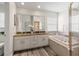 Bathroom featuring a soaking tub, shower with gold trim, and a double vanity with a granite countertop at 3633 Morgans Bluff Ct, Land O Lakes, FL 34639