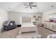 Cozy bedroom with plush carpet, a ceiling fan, accent chair and shelves; abundant natural light at 3633 Morgans Bluff Ct, Land O Lakes, FL 34639