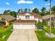 Two-story home showcasing a three-car garage, pristine landscaping, and a charming facade at 3633 Morgans Bluff Ct, Land O Lakes, FL 34639