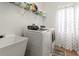 Well-equipped laundry room features a utility sink, modern washer and dryer, and ample shelving at 3633 Morgans Bluff Ct, Land O Lakes, FL 34639