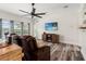 Bright living room with wood floors, a ceiling fan, and sliding glass doors offering a serene view at 3633 Morgans Bluff Ct, Land O Lakes, FL 34639