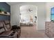 View of the carpeted main bedroom with a seating area, ceiling fan, and open bathroom with double vanity at 3633 Morgans Bluff Ct, Land O Lakes, FL 34639