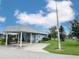 Exterior view of a quaint house with a covered carport and outdoor seating area at 3854 Trophy Blvd, New Port Richey, FL 34655