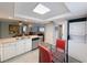 Open kitchen features white cabinets, stainless steel appliances, and a view into the living room at 3854 Trophy Blvd, New Port Richey, FL 34655