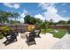 Backyard with cozy fire pit, Adirondack chairs, and lush greenery, perfect for outdoor entertaining at 3905 31St W Ave, Bradenton, FL 34205