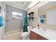 Bright bathroom with a shower-tub combo, modern fixtures, and storage shelves at 3905 31St W Ave, Bradenton, FL 34205