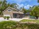 Home features an enclosed porch, swimming pool, spacious lawn, and mature trees at 4044 Red Fox Ct, Wesley Chapel, FL 33543