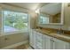 Bathroom featuring double sinks with granite countertops and a window view of greenery at 4044 Red Fox Ct, Wesley Chapel, FL 33543