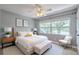 Bright bedroom featuring a large window, ceiling fan, neutral decor, and comfortable furnishings at 4044 Red Fox Ct, Wesley Chapel, FL 33543