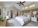Staged main bedroom with vaulted ceilings, ensuite bathroom and hardwood floors at 4044 Red Fox Ct, Wesley Chapel, FL 33543