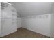 A closet features hardwood flooring, ample shelving and storage, and modern lighting, for the perfect organizing space at 4044 Red Fox Ct, Wesley Chapel, FL 33543