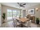 Bright dining room featuring modern ceiling fan, table, and large window showcasing the landscaped yard at 4044 Red Fox Ct, Wesley Chapel, FL 33543