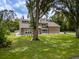 Charming home features large windows, manicured lawn, and mature trees at 4044 Red Fox Ct, Wesley Chapel, FL 33543
