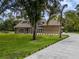Charming home features a palm tree, large windows, and long driveway at 4044 Red Fox Ct, Wesley Chapel, FL 33543